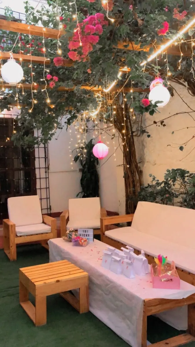 Terraza de Vegan Garden con buganvilias, faroles y luces