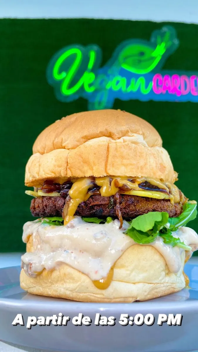 Hamburguesa vegana frente al letrero de neón de Vegan Garden